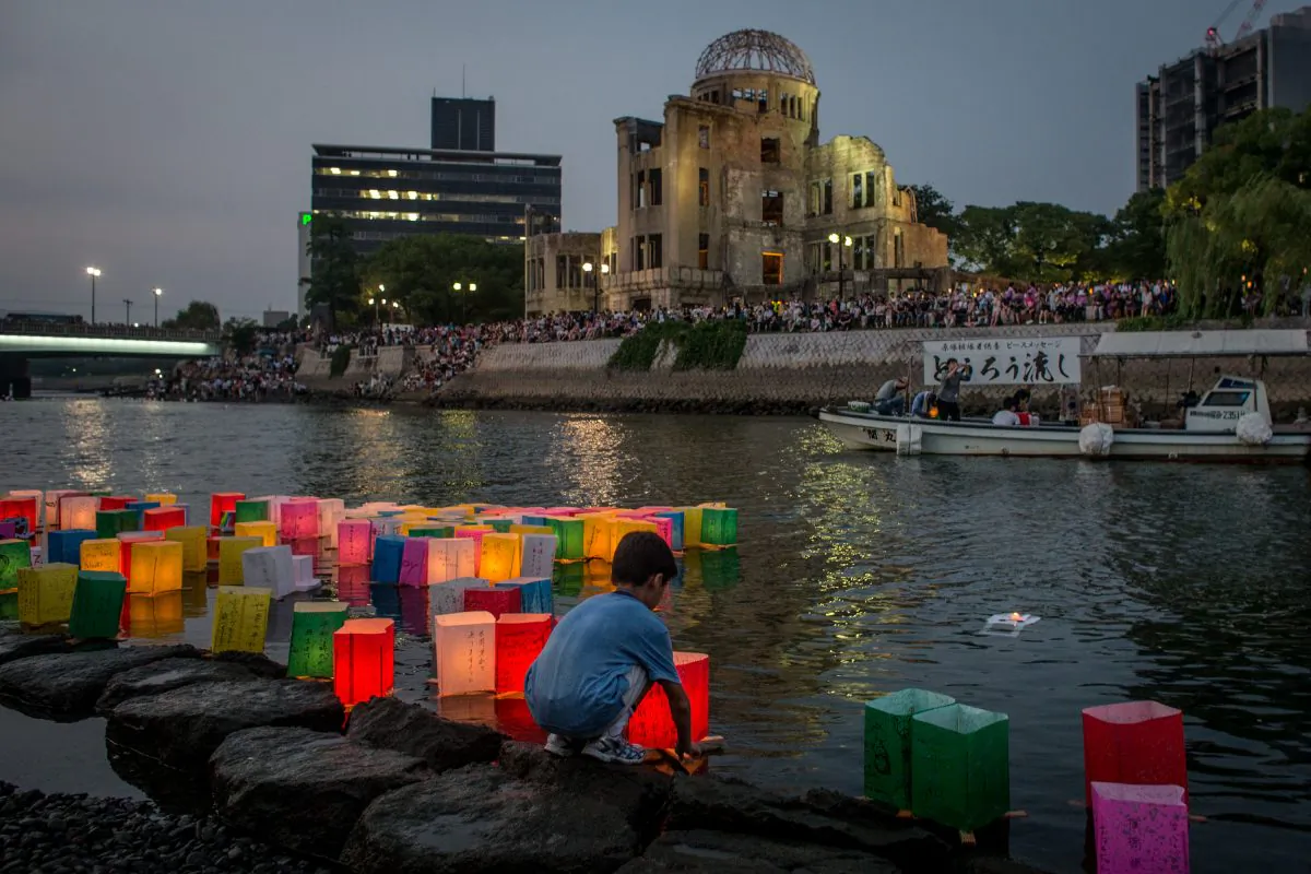 A boy floats a candle lit paper lantern on the river in front of the Atomic Bomb Dome during 70th anniversary activities, commemorating the atomic bombing of Hiroshima, Japan, at the Hiroshima Peace Memorial Park on Aug. 6, 2015. (Chris McGrath/Getty Images)