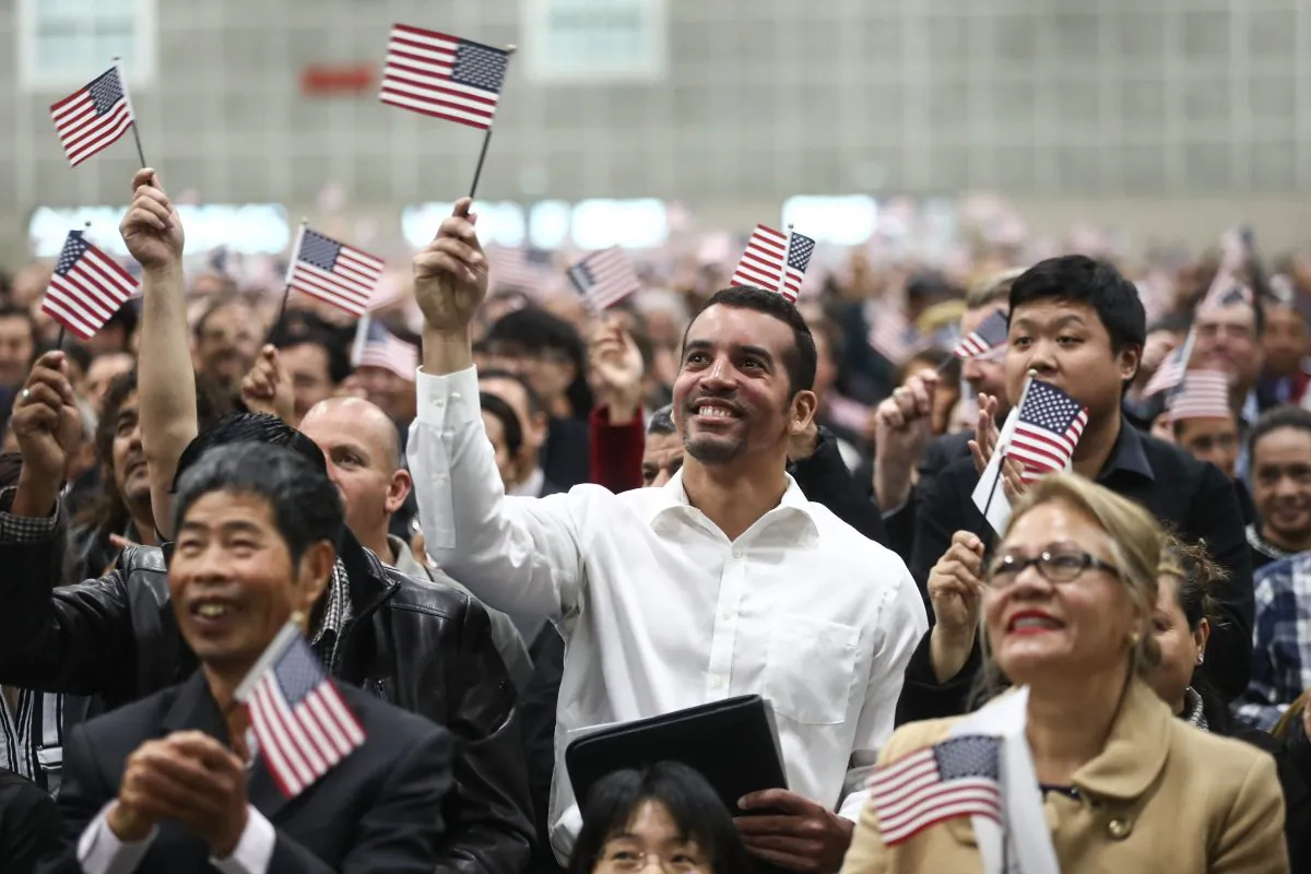 New U.S. citizens wave American flags at a naturalization ceremony on March 20, 2018 in Los Angeles. (Mario Tama/Getty Images)