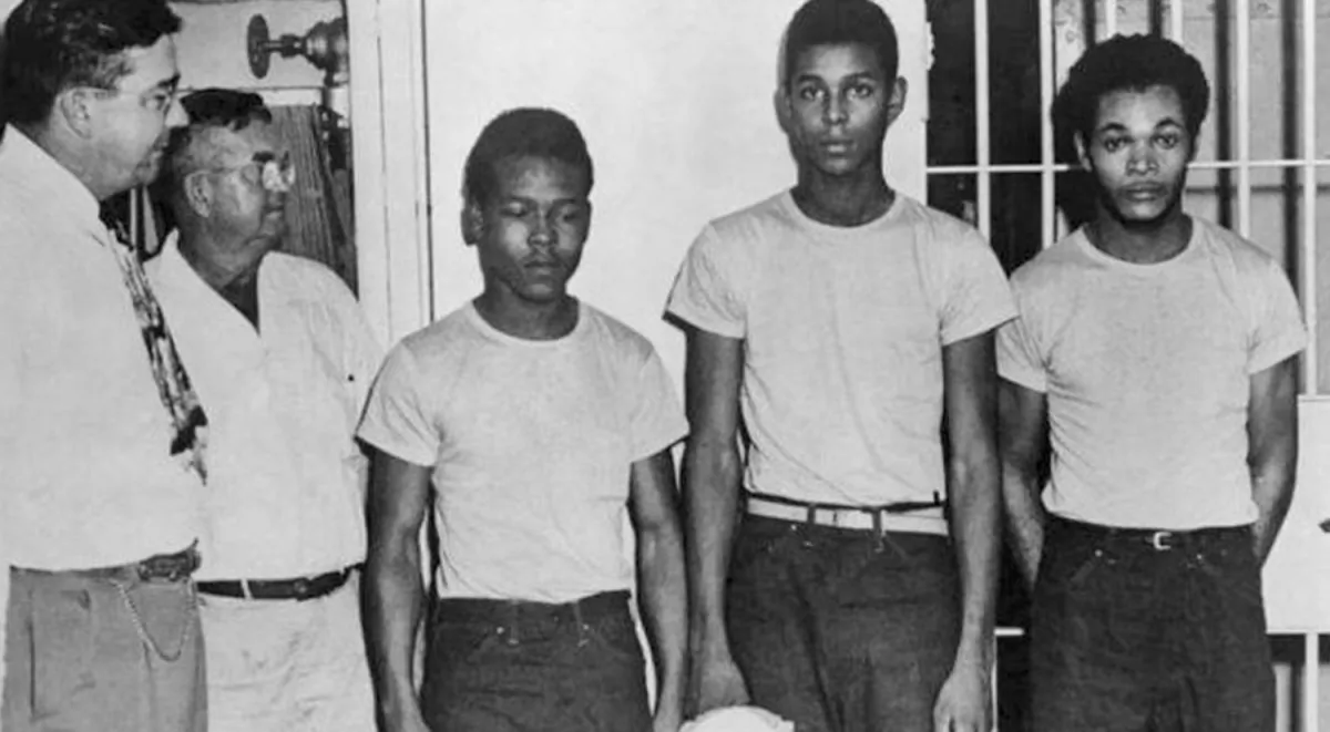 In this undated image released by the State Library and Archives of Florida, Lake County Sheriff Willis McCall, far left, and an unidentified man stand next to Walter Irvin, Samuel Shepherd and Charles Greenlee, from left, in Florida. (State Library and Archives of Florida/AP)