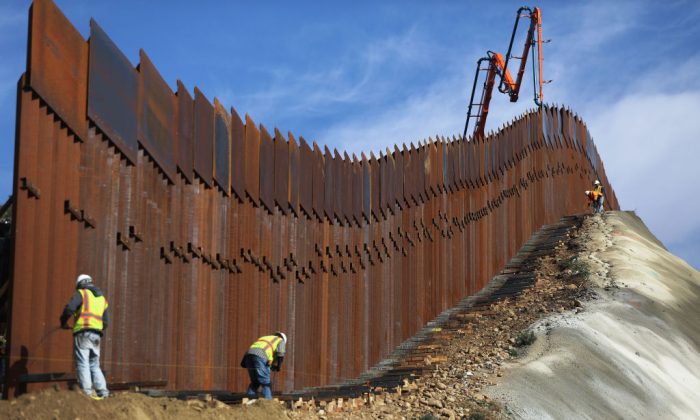 A construction crew works as new sections of the U.S.-Mexico border barrier are installed replacing smaller fences, as seen from Tijuana, Mexico, on Jan. 11, 2019. (Mario Tama/Getty Images)