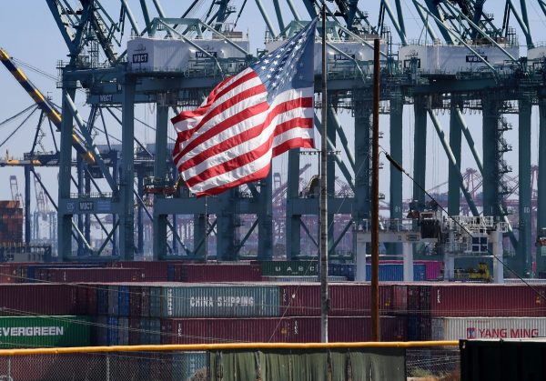 The US flag flies over Chinese shipping containers that were unloaded at the Port of Long Beach, in Los Angeles County