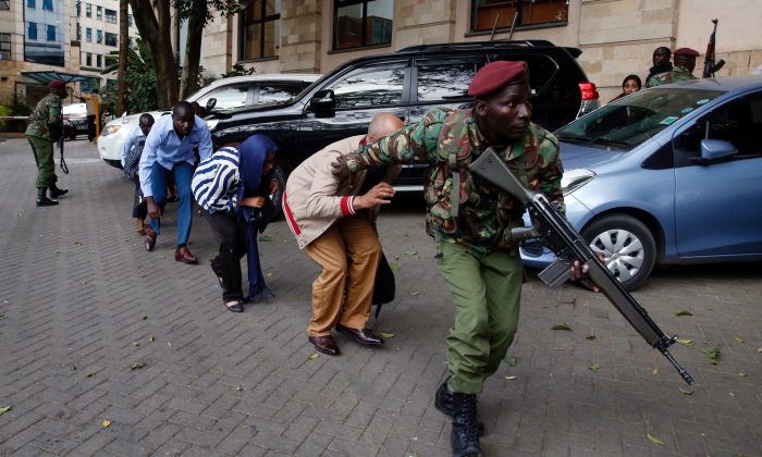 People are evacuated by a member of security forces at the scene where explosions and gunshots were heard at the Dusit hotel compound, in Nairobi, Kenya, Jan. 15, 2019. (Reuters/Baz Ratner)