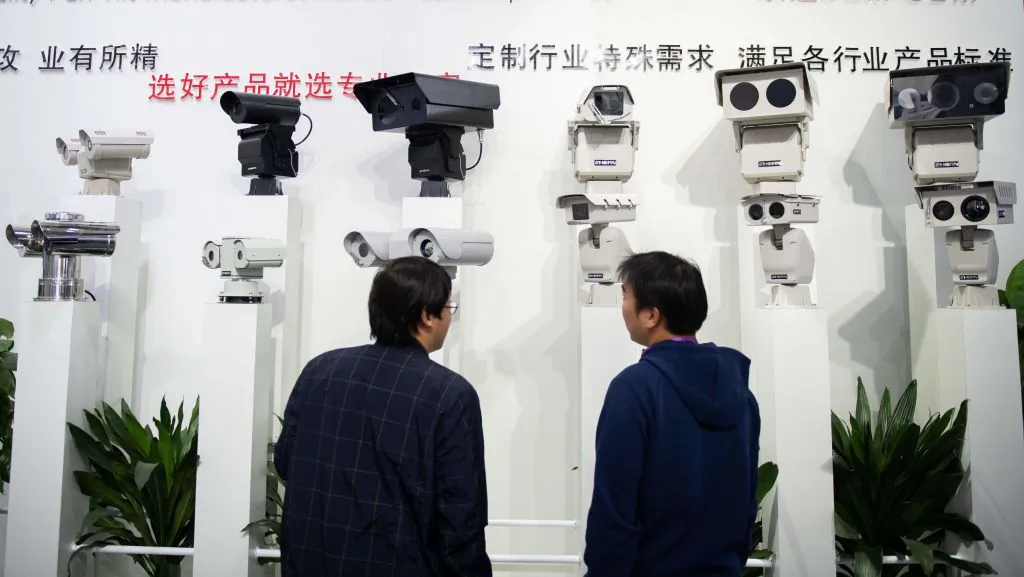 Visitors look at artificial-intelligence security cameras using facial recognition technology at the 14th China International Exhibition on Public Safety and Security at the China International Exhibition Center in Beijing on Oct. 24, 2018. (Nicolas Asfouri/AFP/Getty Images)