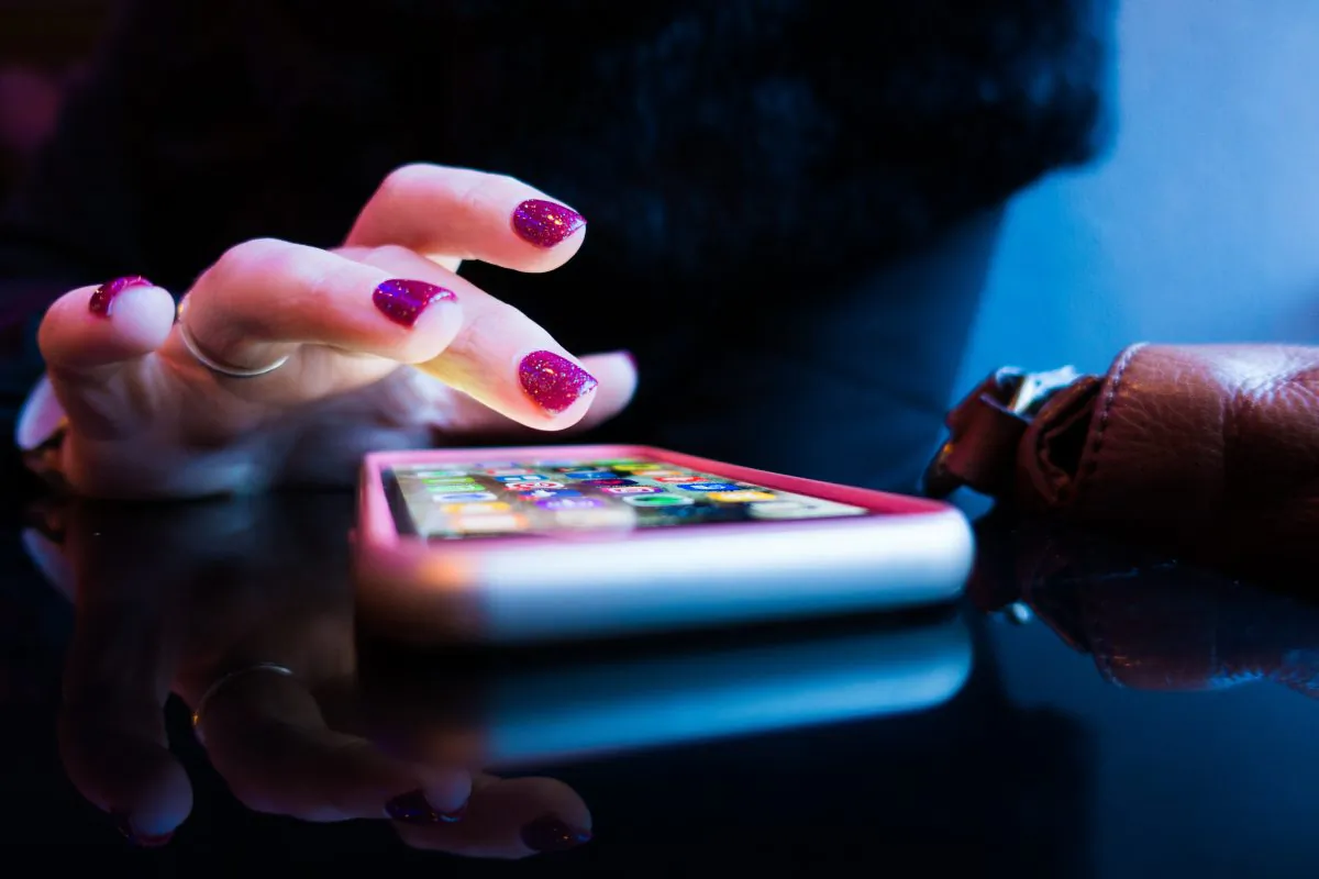 A woman sends a text message on her cell phone in this undated photo. (Rob Hampson/Unsplash)
