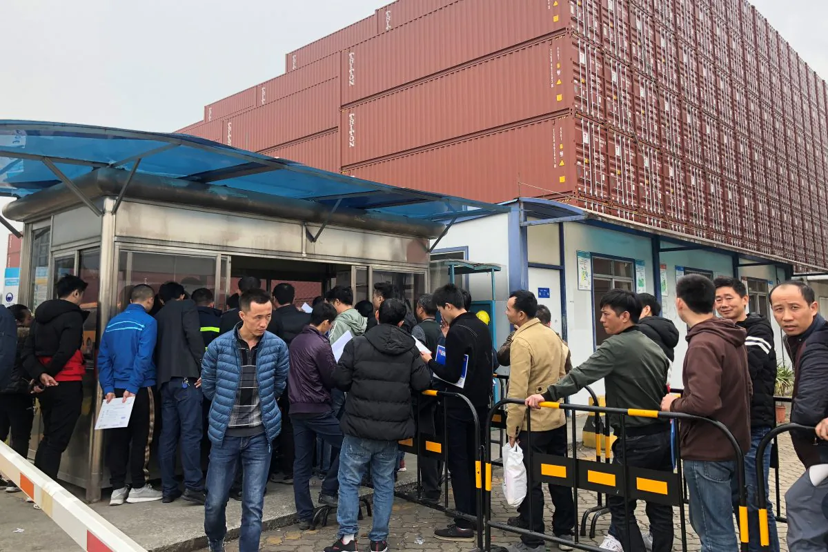 Workers queue to collect their employee contract termination letters at a Maersk container factory in Dongguan, Guangdong Province, China on Jan. 7, 2019. (Stella Qiu/Reuters)