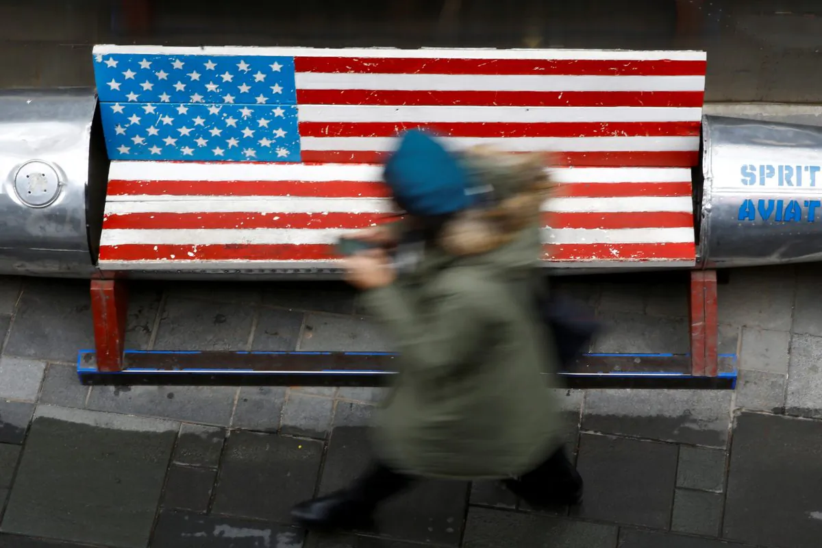 A woman walks past a bench painted in the colors of the U.S. flag outside a clothing store in Beijing on Jan. 7, 2019. (Thomas Peter/Reuters)
