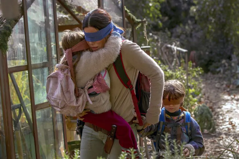 This image released by Netflix shows Sandra Bullock in a scene from the film, "Bird Box." Netflix’s post-apocalyptic survival film is drawing criticism for using footage of a real fiery train disaster but the streaming giant has no plans to remove it. The footage concerns a 2013 tragedy in the Quebec town of Lac-Megantic when an unattended train carrying crude oil rolled down an incline, came off the tracks and exploded into a massive ball of fire, killing 47 people. (Saeed Adyani/Netflix via AP)