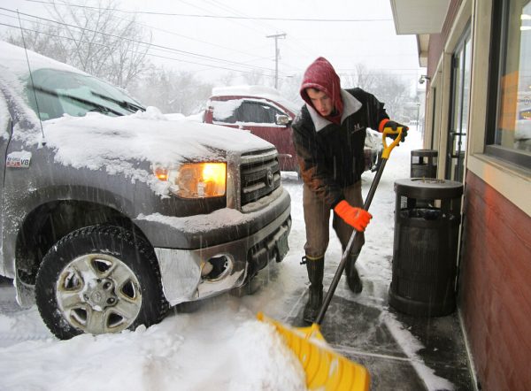 Carter Martin shovels a sidewalk