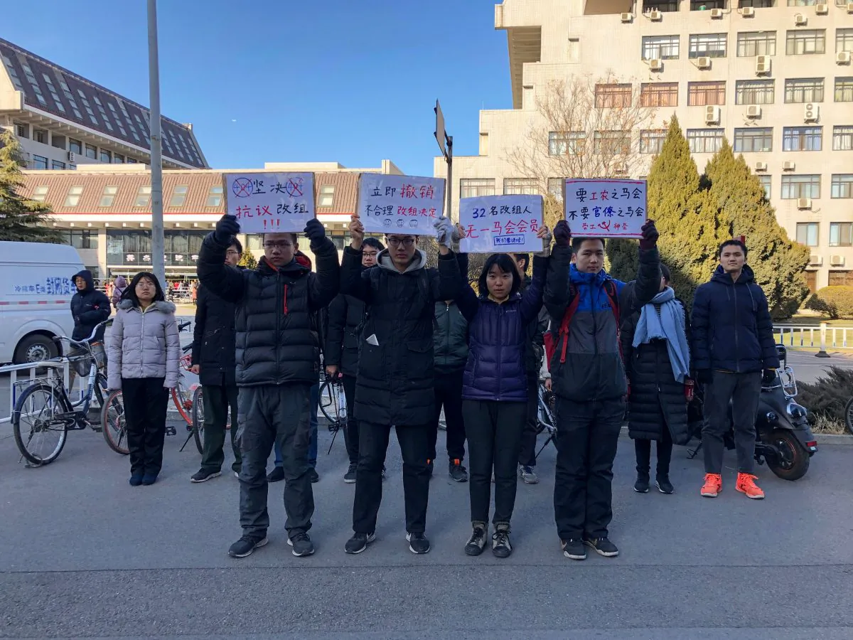 Four students hold up signs as they protest against the change in a student-run Marxist group's leadership at Peking University amid an ongoing crackdown on student activists in Beijing on Dec. 28, 2018. (Eva Xiao/AFP/Getty Images)