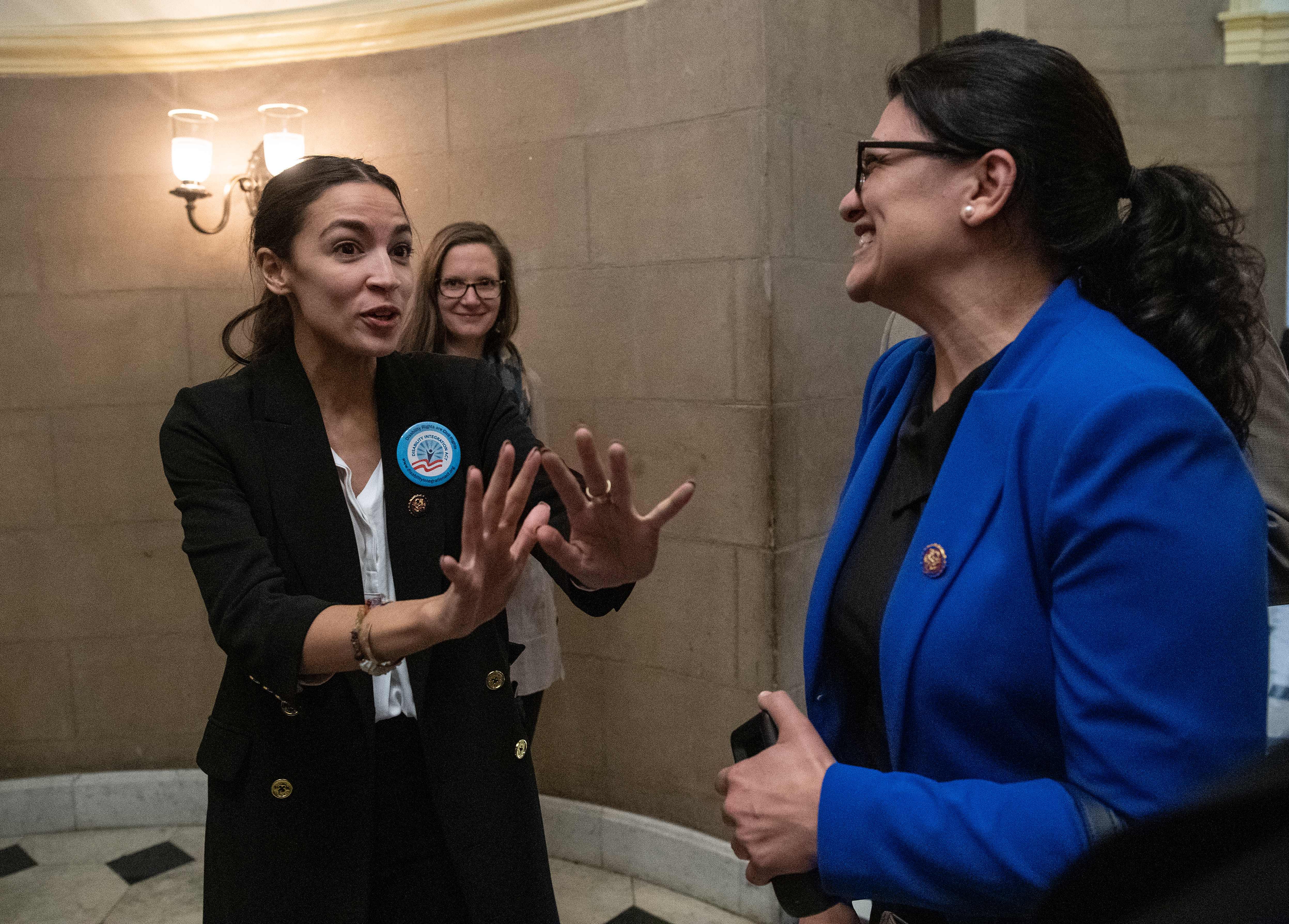 Alexandria Ocasio Cortez (L) speaks with Democratic Representative from Michigan Rashida Tlaib