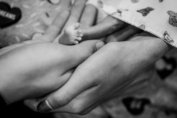 Young mother Brianna holds baby's foot