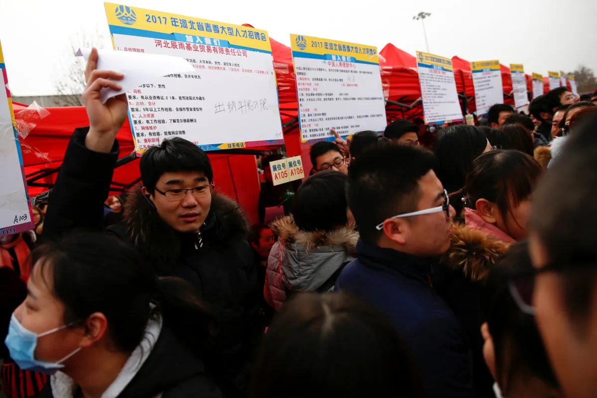 Recruiters and job seekers crowd an open air employment fair for college graduates and the general public in the center of Shijiazhuang, Hebei Province, China on Feb. 6, 2017. (Thomas Peter/Reuters)