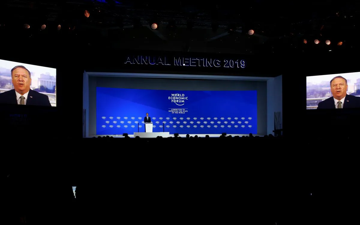 Borge Brende, President of World Economic Forum stands on a stage while U.S. Secretary of State Mike Pompeo is seen on screens as he addresses attendees via satellite, during the World Economic Forum (WEF) annual meeting in Davos, Switzerland on Jan. 22, 2019. (Arnd Wiegmann/Reuters)