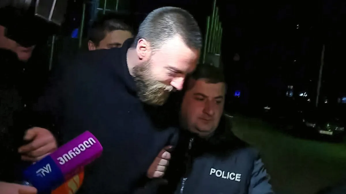 Jack Shepherd, who went on the run last year after killing a woman in a speedboat crash on the River Thames, is escorted by police officers in Tbilisi, Georgia, on Jan. 23, 2019. (Screenshot/IMEDI TV/Reuters)