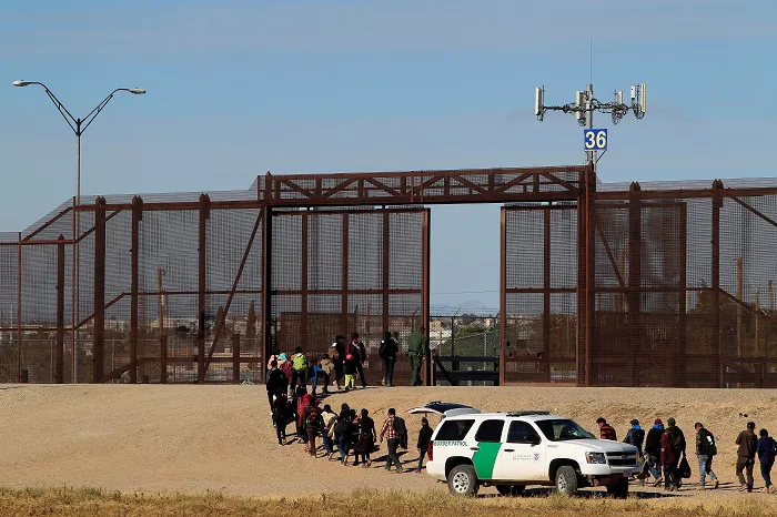 Migrants from Central America are seen escorted by U.S. Customs and Border Protection (CBP) officials after crossing the border from Mexico to surrender to the officials in El Paso, Texas, U.S., in this picture taken from Ciudad Juarez, Mexico on December 3, 2018. (Jose Luis Gonzalez/Reuters)