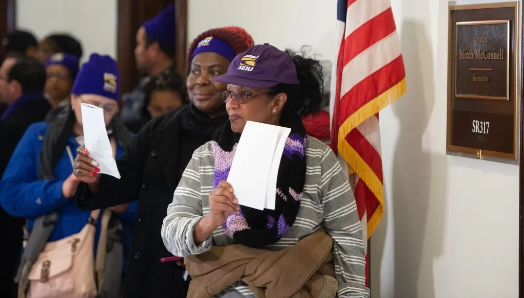 Furloughed contract workers, including security officers and custodians who have not been paid during the partial government shutdown, hold unpaid bills to present to the office of Senate Majority Leader Mitch McConnell on Capitol Hill in Washington, DC, Jan. 16, 2019. (Saul Loeb/AFP/Getty Images)