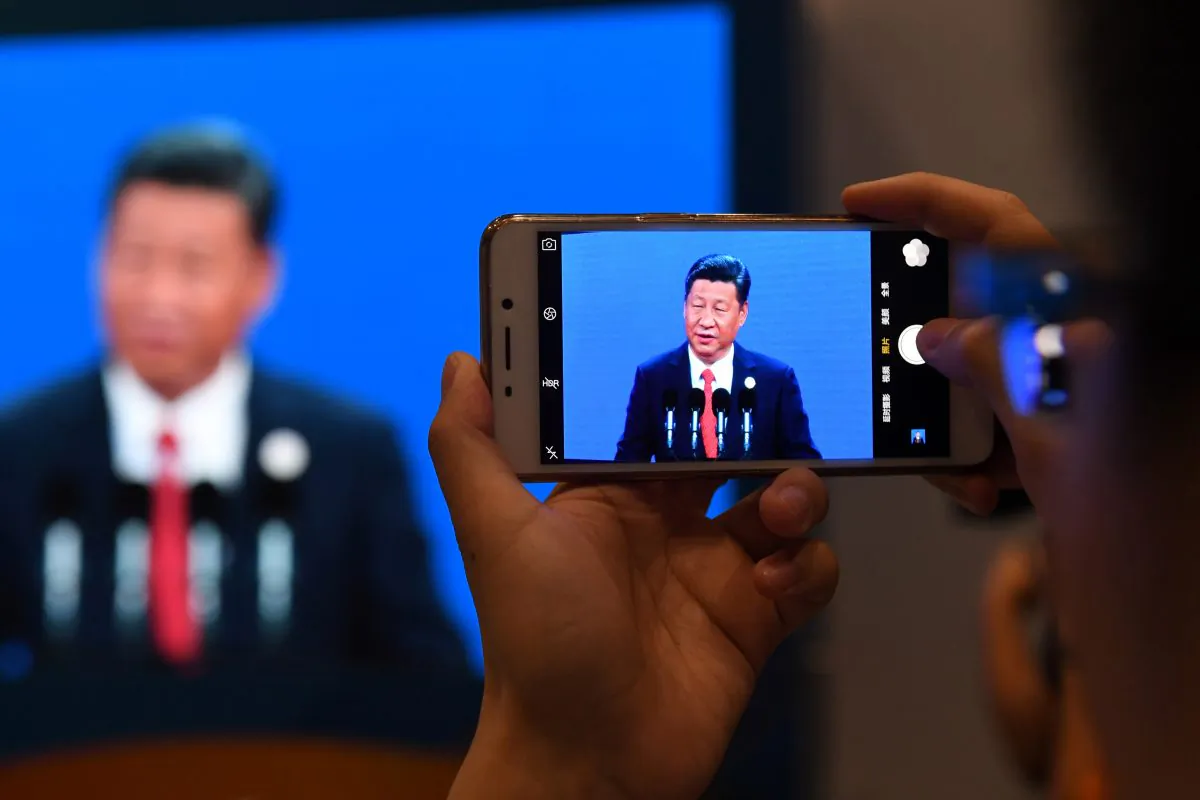 A journalist takes a photo of a live feed of Chinese leader Xi Jinping speaking in Beijing on May 14, 2017. (GREG BAKER/AFP/Getty Images) 