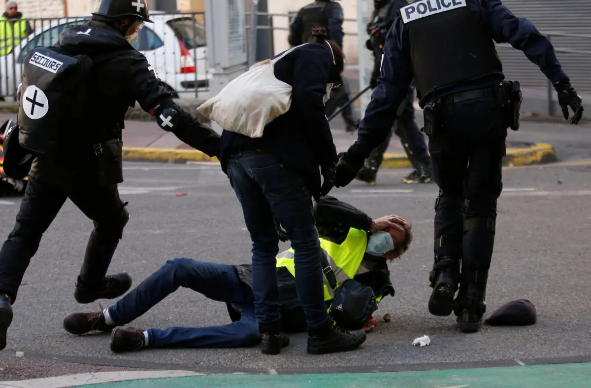 A French police officer apprehends a protester wearing a yellow vest during a demonstration in Marseille, France, on Jan. 26, 2019. (Reuters/Jean-Paul Pelissier)