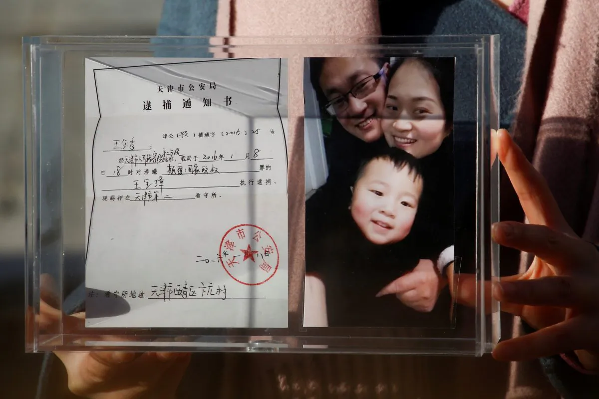 Li Wenzu, the wife of prominent Chinese rights lawyer Wang Quanzhang, holds a box with a family picture and the detention notice for her husband before shaving her head in protest in Beijing, China, Dec. 17, 2018.  (Thomas Peter/Reuters)