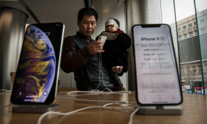 A Chinese man holds his son as they look at iPhones on display at an Apple Store on Jan. 7 in Beijing. (Kevin Frayer/Getty Images)