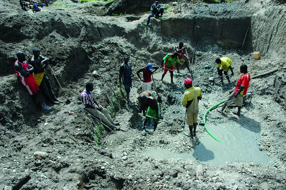 Locals scout around for flecks of gemstone in a mining pit abandoned by a Chinese mining firm in Betare-Oya. (Amindeh Blaise Atabong for The Epoch Times)
