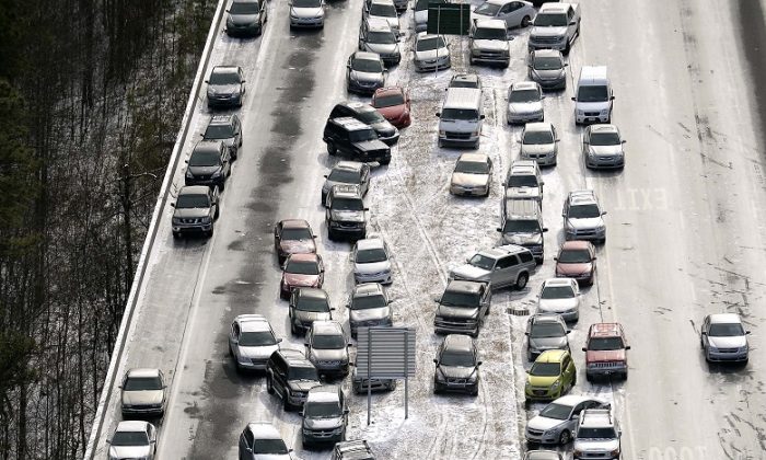 Abandoned cars at I-75 headed northbound near the Chattahoochee River overpass are piled up in the median of the ice-covered interstate after a winter snow storm, in Atlanta on Jan. 29, 2014. (AP Photo/David Tulis, File)