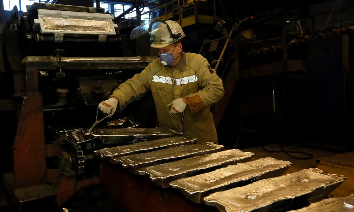 A worker controls forming of aluminum ingots on a conveyor belt at the foundry shop of the Rusal Krasnoyarsk aluminium smelter in Krasnoyarsk, Russia on Oct. 3, 2018. (Ilya Naymushin/Reuters)