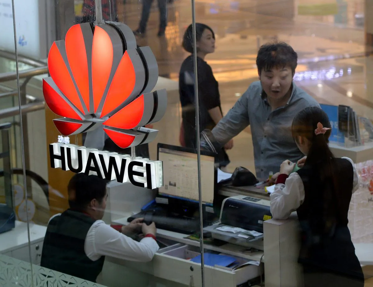 An employee uses a computer as she deals with a customer at a Huawei store in Beijing on March 24, 2014. (MARK RALSTON/AFP/Getty Images)