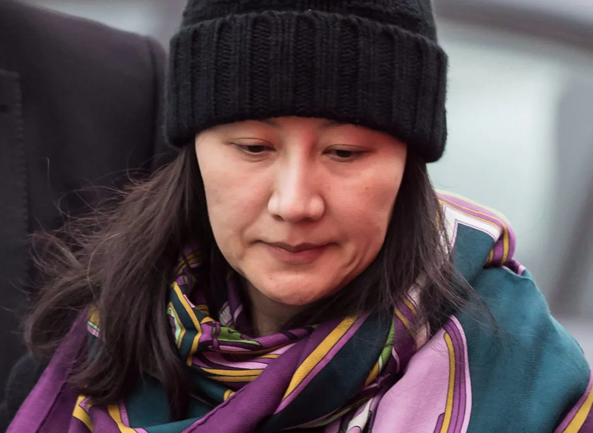 Huawei chief financial officer Meng Wanzhou is escorted by her private security detail while arriving at a parole office, in Vancouver, Canada on Dec. 12, 2018. Meng requested an amendment to her bail conditions on Jan. 29, 2019. (THE CANADIAN PRESS/Darryl Dyck)