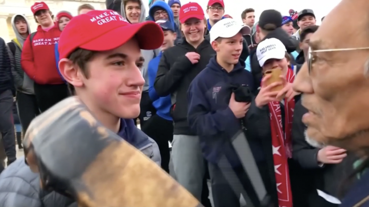 Nick Sandmann from Covington Catholic High School stands in front of Native American actvist Nathan Phillips while the latter bangs a drum in his face in Washington on Jan. 18, 2019. (Kaya Taitano via Reuters)