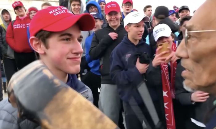 Nick Sandmann from Covington Catholic High School stands in front of Native American activist Nathan Phillips while the latter bangs a drum in his face in Washington on Jan. 18, 2019. (Kaya Taitano via Reuters)
