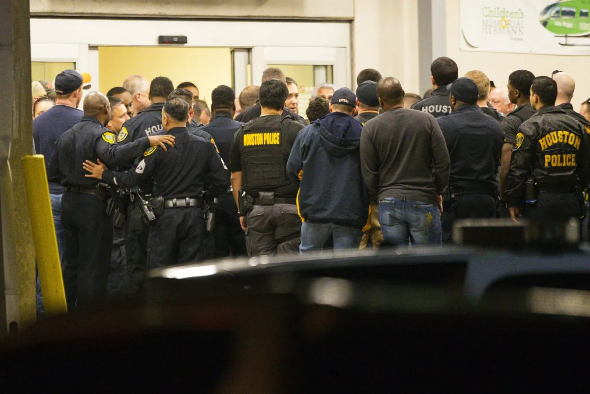 Officers listen as Houston Police Chief Art Acevedo comes outside of the emergency department at Memorial Hermann Hospital after visiting injured officers in the Texas Medical Center, in Houston, on Jan. 28, 2019. (Mark Mulligan/Houston Chronicle via AP)