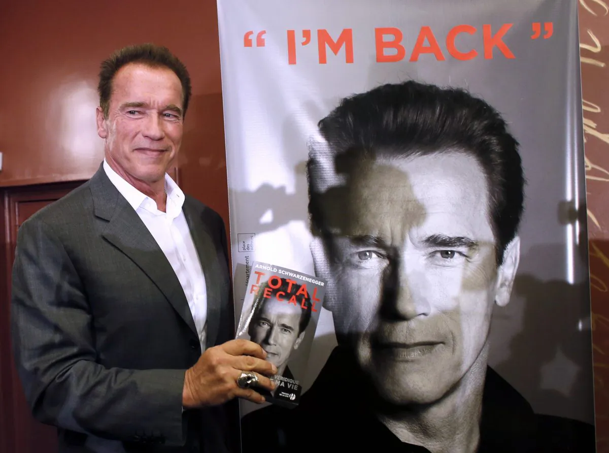 U.S. actor and former California Gov. Arnold Schwarzenegger holds his autobiography titled "Total Recall" after a press conference, on Oct. 12, 2012, in Paris. (Patrick Kovarik/AFP/Getty Images)