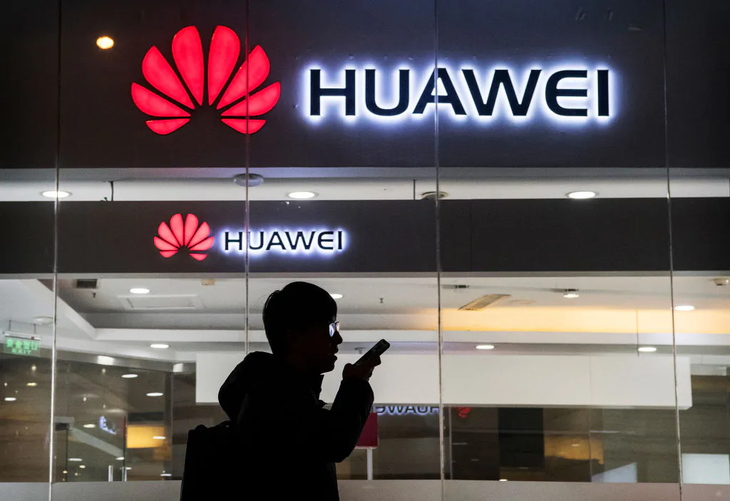 A pedestrian talks on the phone while walking past a Huawei store in Beijing on Jan. 29, 2019. (Kevin Frayer/Getty Images)