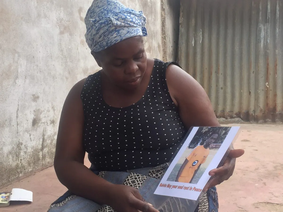 Ellen Juru holds a photograph of her son, Tinashe, who was shot during protests in Harare, Zimbabwe, on Jan. 14, 2019. (Sally Nyakanyanga for The Epoch Times)