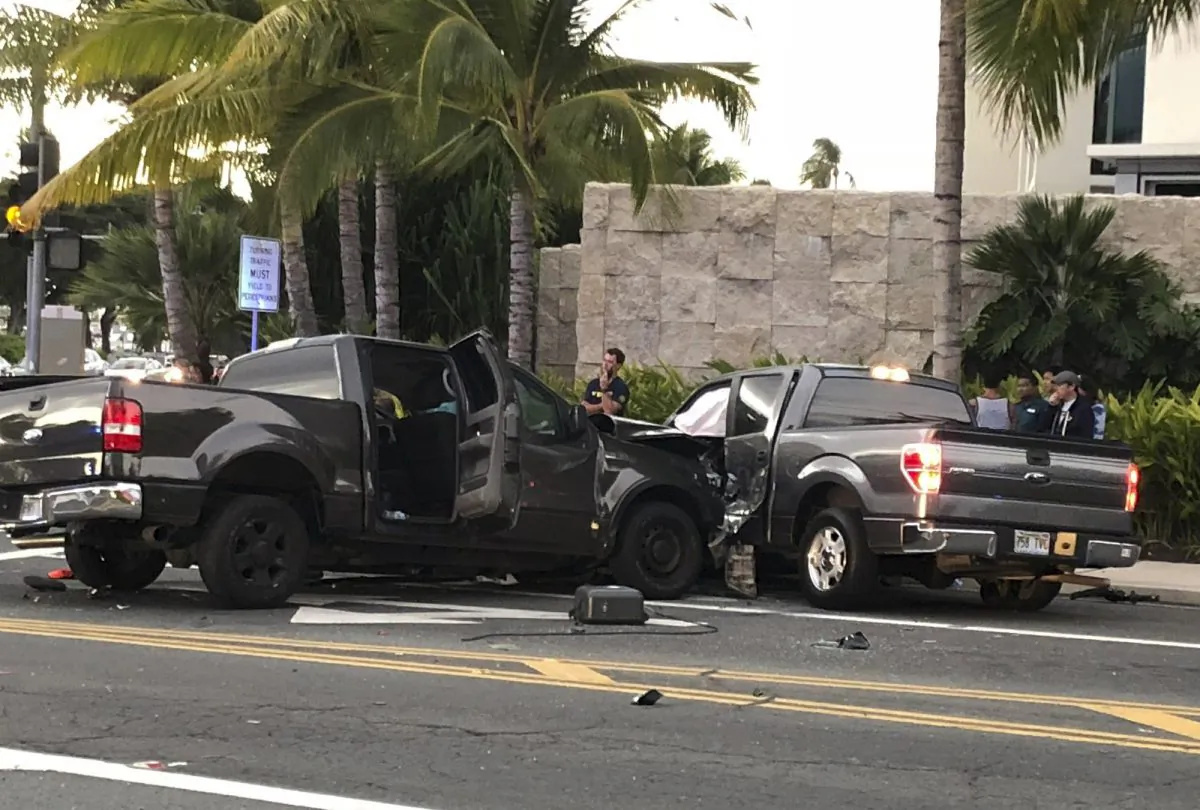 In this photo taken Monday, Jan. 28, 2019, is the scene of a multiple vehicle accident involving two trucks and a bicyclist in Honolulu. (Cindy Ellen Russell/Honolulu Star-Advertiser via AP)