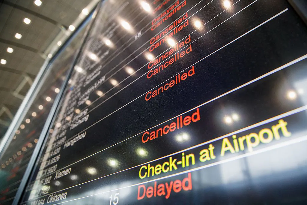 An information display showing lists of canceled and delayed flights is seen at the Airport Express station as Typhoon Haima approaches Hong Kong, on Oct. 21, 2016, during a typhoon signal number eight warning. (Anthony Wallace/AFP/Getty Images)