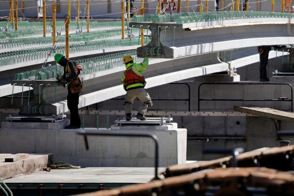 Construction workers guide a piece of a bridge in to place in Baltimore