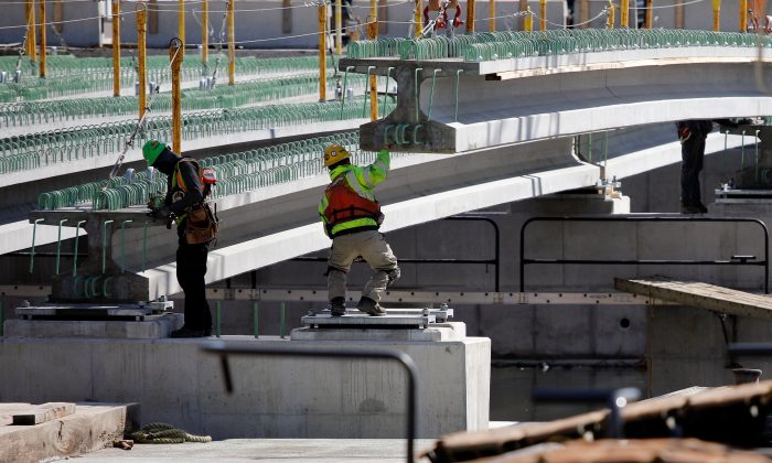 Construction workers guide a piece of a bridge into place in Baltimore, Md., on March 26, 2018. (David Gannon/AFP/Getty Images)