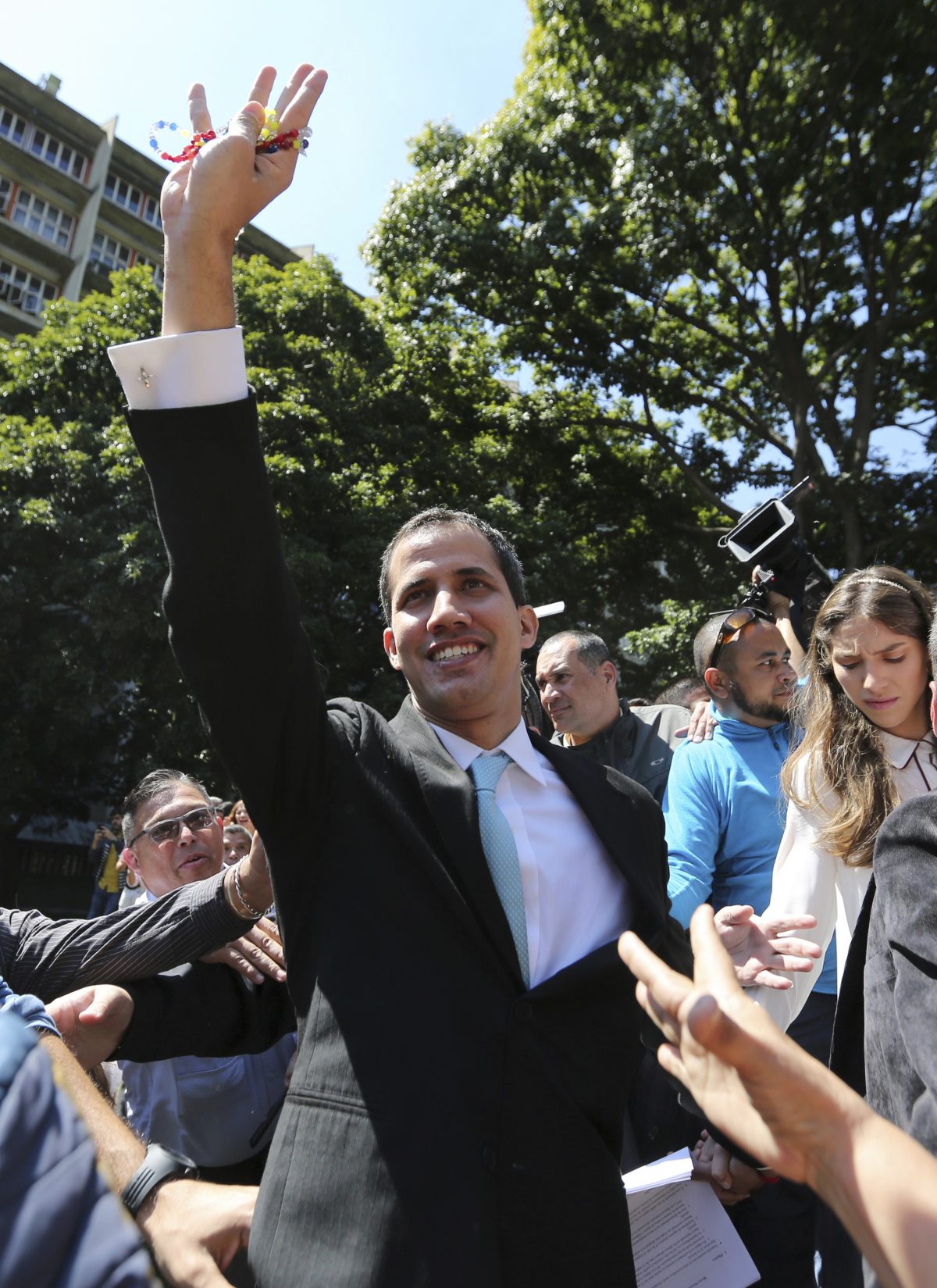 Opposition National Assembly President Juan Guaido greets supporters upon his arrival to the Venezuelan Central University for a conference on economic plans for reviving the country in Caracas, Venezuela, Thursday, Jan. 31, 2019. An independent U.N. human rights monitor says economic sanctions are compounding a "grave crisis" in Venezuela. (AP/Fernando Llano)