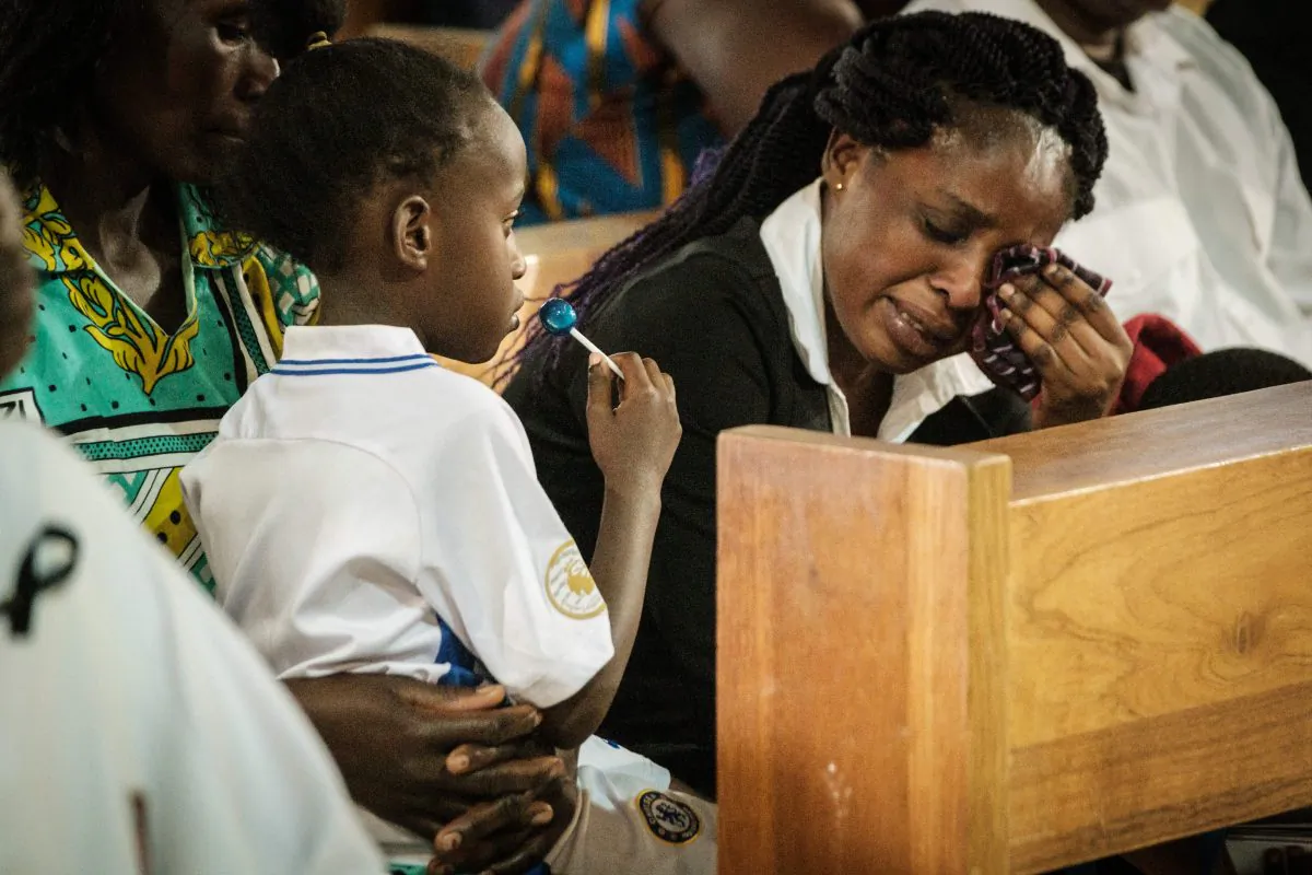 The wife of a staff member at the DusitD2 hotel cries next to one of her children during a memorial service on Jan. 23, 2019, for six staff members of the hotel who were killed during an attack at the Consolata Shrine in Nairobi, Kenya. (Yasuyoshi Chiba/AFP/Getty Images)