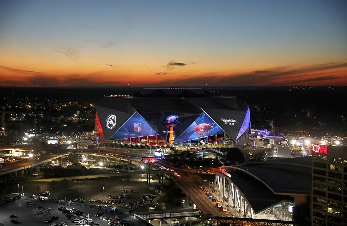 The sun sets behind Mercedes-Benz Stadium ahead of Sunday's NFL Super Bowl 53 football game between the Los Angeles Rams and New England Patriots in Atlanta, on Jan. 30, 2019. (AP Photo/David Goldman)