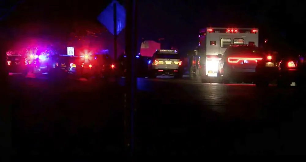 Lights illuminate police vehicles as authorities respond to a standoff at an apartment complex in Ohio, about 20 miles east of Cincinnati on Feb. 3, 2019. (FOX19Now.com via AP)