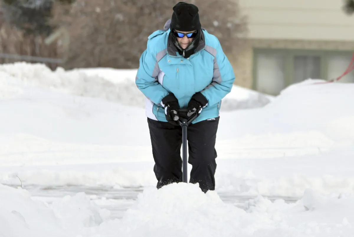 Florence Leingang clears the sidewalk of snow in front of her home in Mandan, N.D., on Feb. 4, 2019. (Mike McCleary/The Bismarck Tribune via AP)