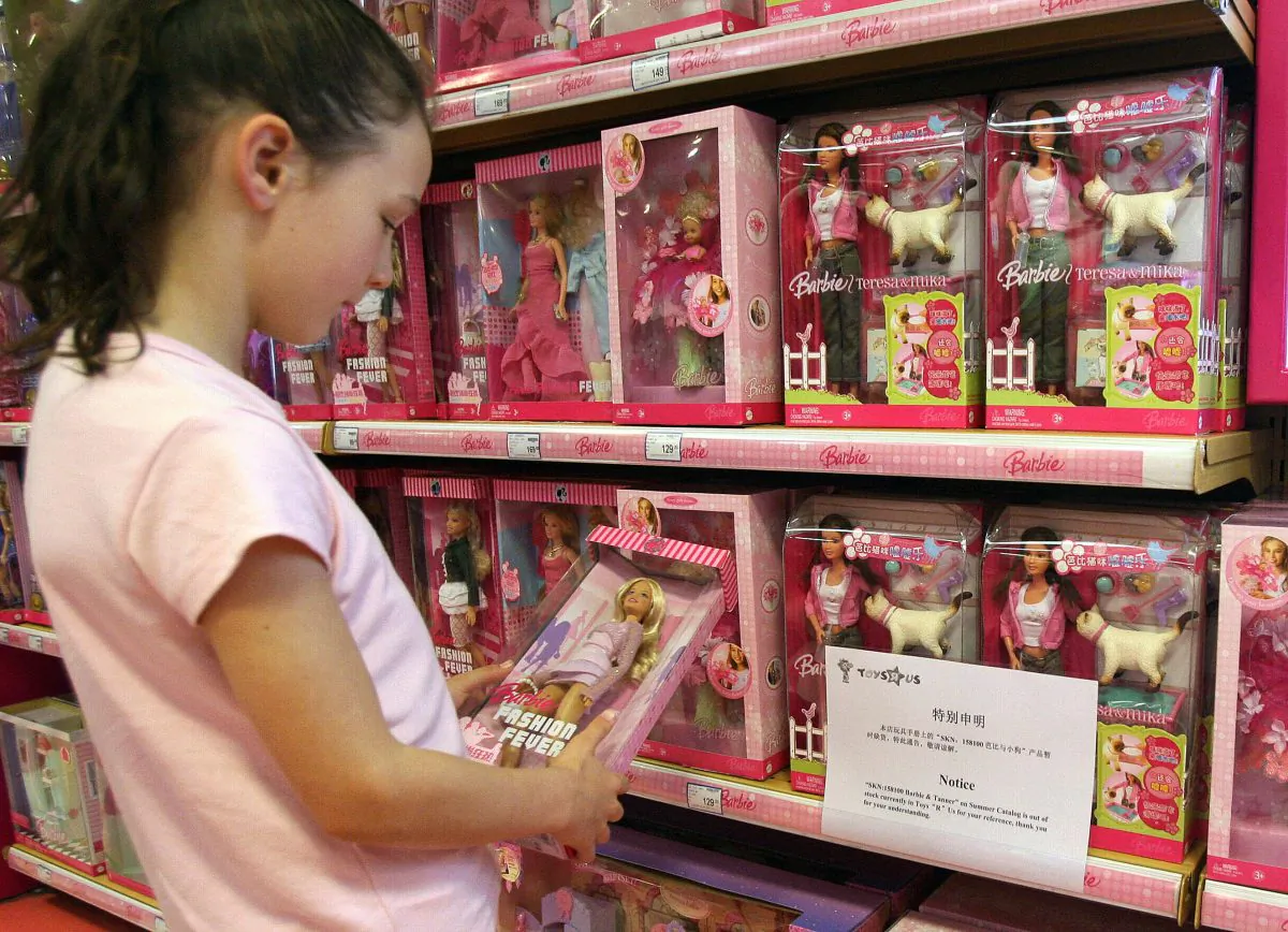 A young girl holds a Barbie doll next to a notice saying that the toy 'Barbie and Tanner' made by US toy giant Mattel, which has just been recalled in the US, is out of stock at a Toys 'R' Us store in Shanghai, 15 August 2007. (MARK RALSTON/AFP/Getty Images)