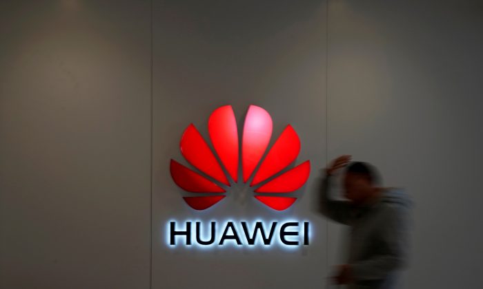 A man walks by a Huawei logo at a shopping mall in Shanghai, China on Dec. 6, 2018. (Aly Song/Reuters)