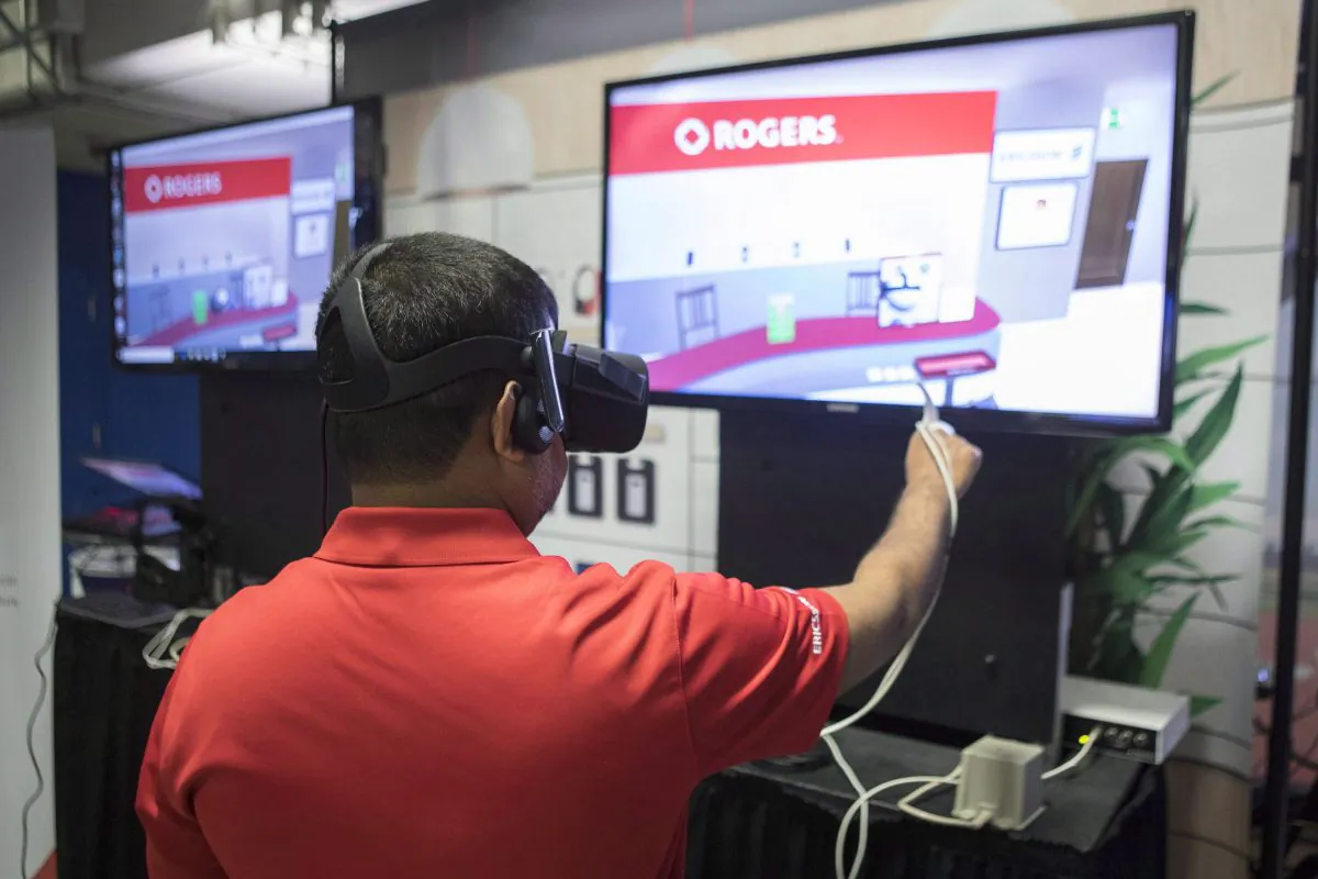 A Rogers employee wears virtual reality (VR) goggles at a stall promoting VR retail over 5G wireless networks, at a press event in Toronto, Canada on April 16, 2018. (The Canadian Press/Chris Young)
