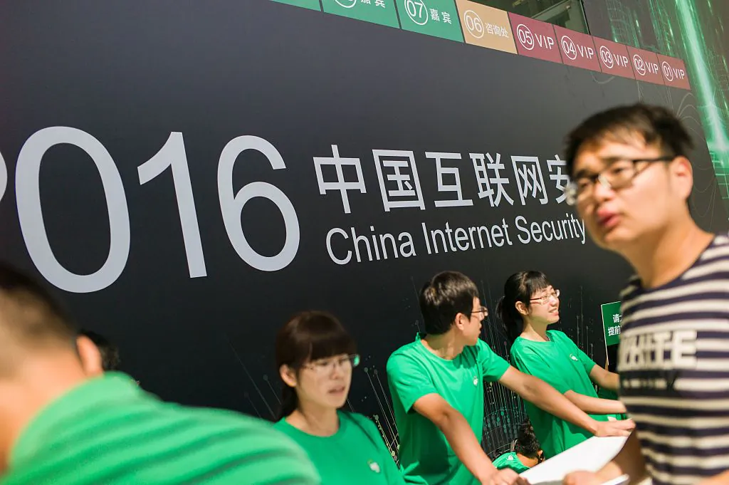 Chinese volunteers wait for attendees at the China Internet Security Conference in Beijing on Aug. 16, 2016. (Fred Dufour/AFP/Getty Images)