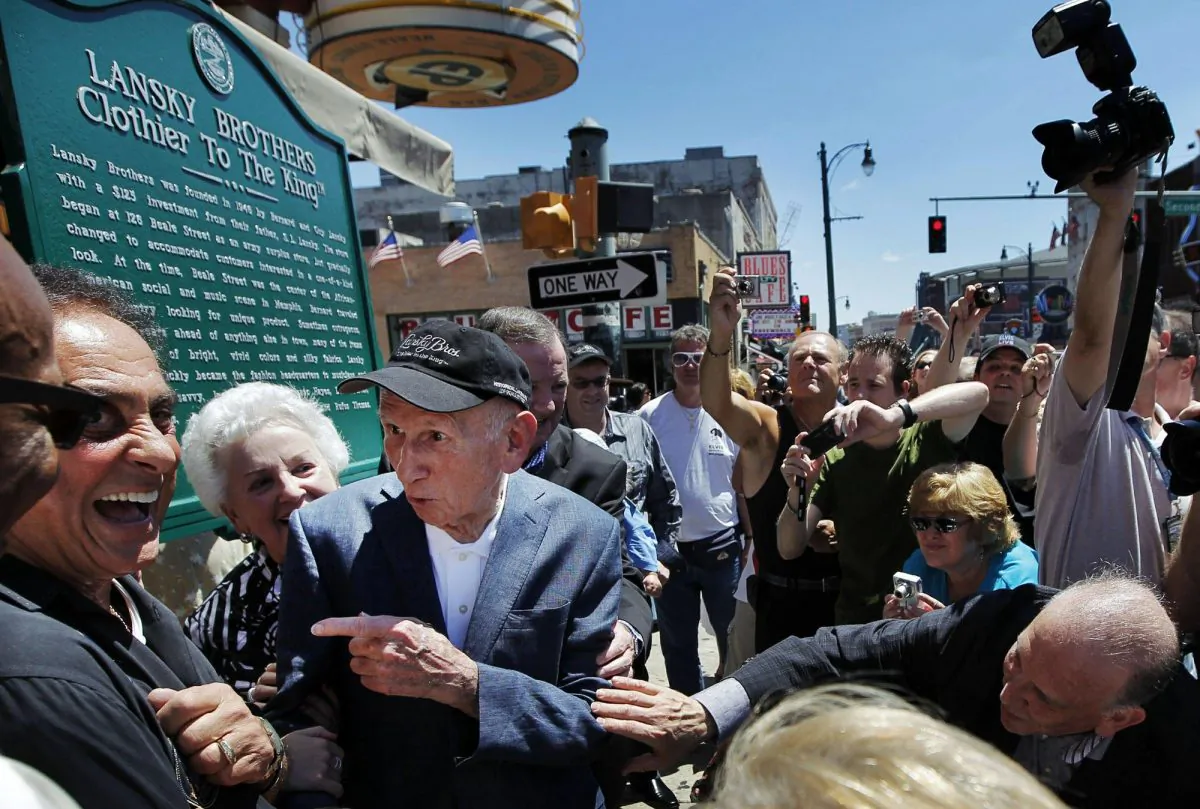 Memphis DJ George Klein, left, jokes with Lansky Brothers founder Bernard Lansky, second from left, "Clothier to the King" during the unveiling of a new plaque to mark the original location of the historic clothing store on Beale St. in Memphis, Tenn., on Aug. 14, 2011. (Jim Weber/The Commercial Appeal via AP, File)