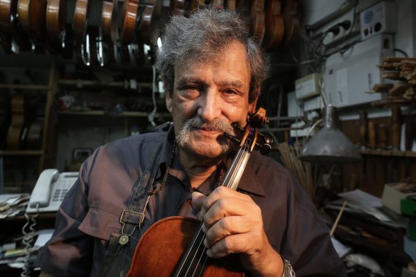 Israeli violin maker Amnon Weinstein holds a violin
